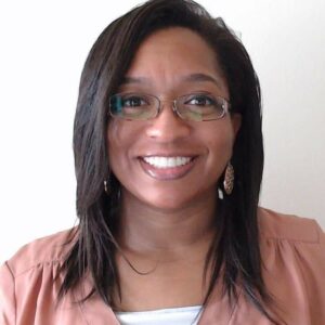 Black woman in glasses wearing a pink shirt