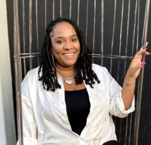 Picture of a Black woman in a white shirt over a black shirt